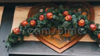 德国圣诞市场商<strong>店门口</strong>放着红苹果的圣诞枞树花圈，上面刻着